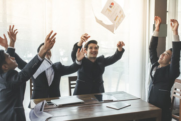 Asia business people throwing paper teamwork They smile sitting on chair at the office with her colleagues Job success