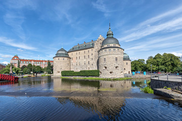 Orebro castle reflecting in water on sunny summer day in city Orebro, Sweden