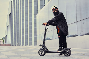 A man vaping and riding by electric scooter.