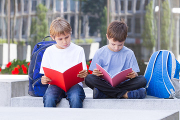 Children with backpacks and books outdoors.