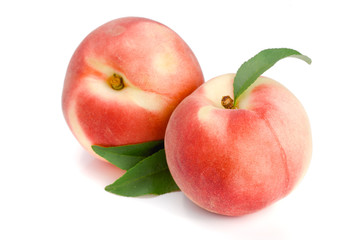 Two peaches with green leaf isolated on white background