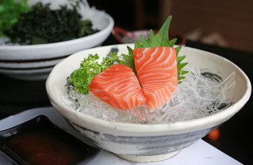 Sliced salmon raw sashimi on ice.