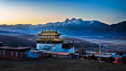 Chinese temple or tibet style with Landscape View snow of Mountain in the winter season and landmarks public place in Long Youth Cole temple Ganzi, Sichuan, China at morning twilight - obrazy, fototapety, plakaty