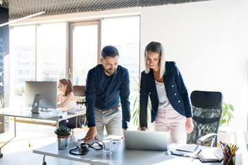 Three business people in the office working together.