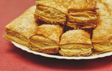 Puff pastry cakes with sugar powder close up