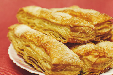 Puff pastry cakes with sugar powder close up