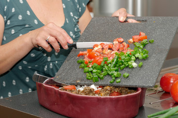 woman cutting tomato with the knife, on a  plate