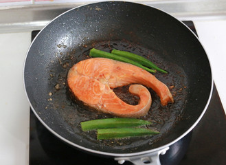 Fried salmon steak with vegetables. Seafood steak fried in a pan.