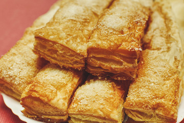 Puff pastry cakes with sugar powder close up