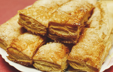 Puff pastry cakes with sugar powder close up