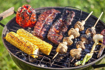 american barbecue - preparing bbq ribs on charcoal grill