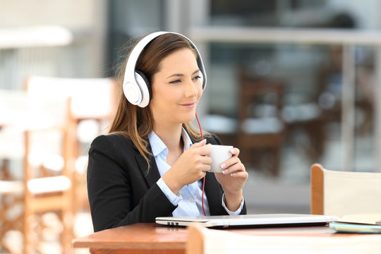 Businesswoman listening music in a coffee break