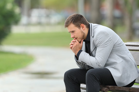 Worried businessman sitting on a bench