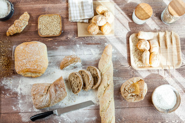 Fresh bread slice and cutting knife on rustic wooden table. Top View