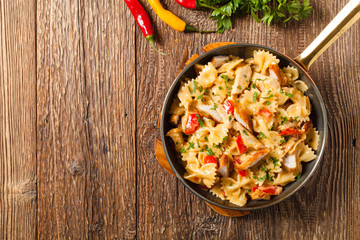 Pasta farfalle with chicken and paprika, in carbonara sauce.