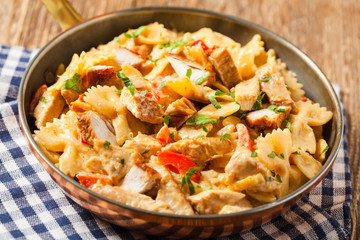 Pasta farfalle with chicken and paprika, in carbonara sauce.