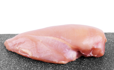 Chicken fillet with spices and rosemary on a dark gray surface.