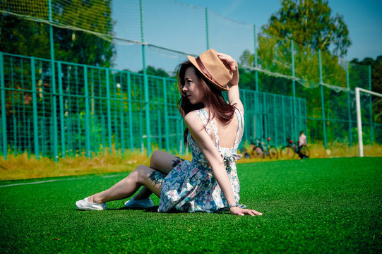 Beautiful young girl in a dress posing at the stadium