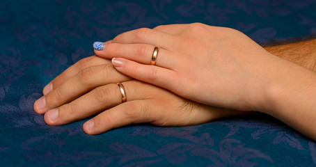 Photo of hands with beautiful wedding rings on blue background