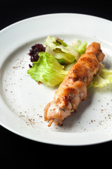 chicken kebab on a skewer with garnish and sauce
