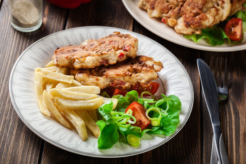 Chicken medallions with red peppers served with chips