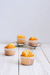 Orange muffins on a white wooden background, minimalism