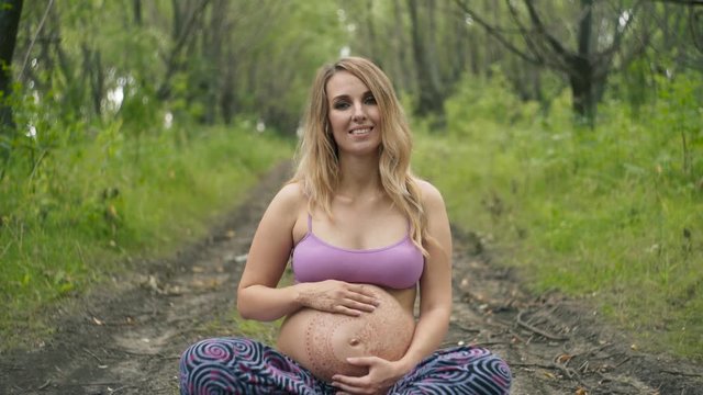 Pregnant girl with henna tattoo mehendi on her belly