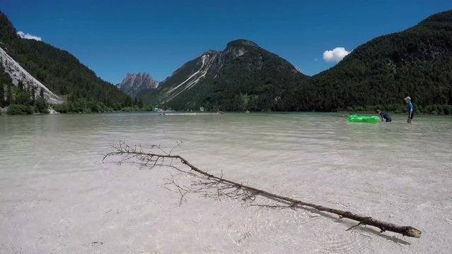 4K. Amazing Alpen Lake in summer, time-lapse with happy people. Predil Lake (Lago Del Predil), alps mountains, Italy, Europe.