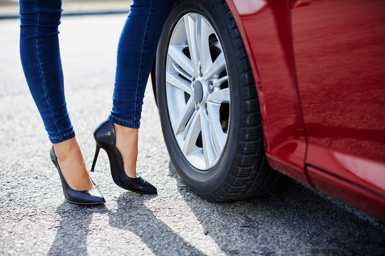 High-heeled black shoes and red car
