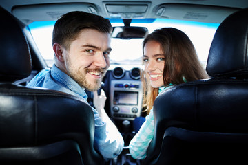 Attractive young couple sitting in car