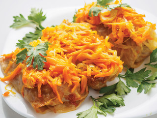 Stuffed cabbage with green and carrot on the plate