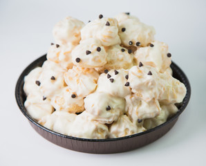 Dish with a lot of sweet profiteroles. White background