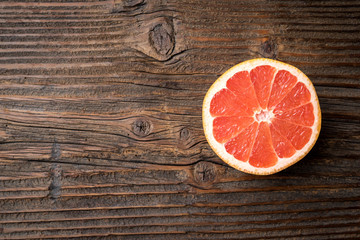 Fototapeta na wymiar Red grapefruit on an old wooden table