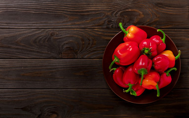 Sweet bulgarian red peppers on a dark wooden background.