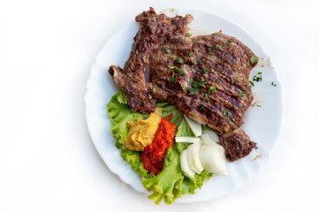 Plate of grilled ribs with traditional Croatian side dish of ajvar
