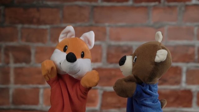 Funny glove puppets over brick background