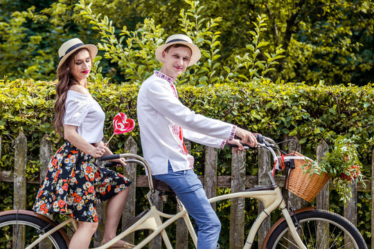 Young couple riding a bike tandem in the park