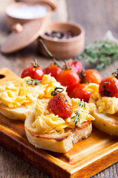 Bruschetta with scrambled eggs and roasted cherry tomatoes