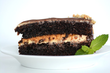 Slice of chocolate birthday cake on white plate