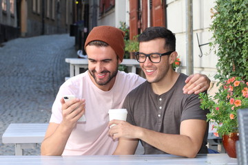 Happy gay couple looking at something on the phone 