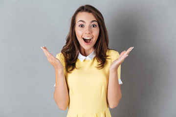 Happy pretty girl standing and gesturing with hands