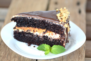 Chocolate cake with almonds and toffee on wooden table
