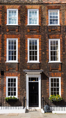 Naklejka premium Typowa scena uliczna w centralnej dzielnicy Londynu ze znanymi fasadami architektury miejskich mieszkań.