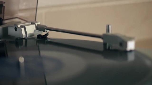 Close up 4k movie of a record player playing a vinyl black record.