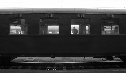 waiting vintage train coach with a man looking out of a window