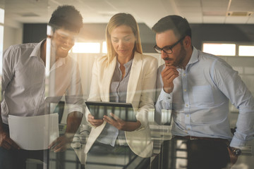 Business people in office having conversation and using digital tablet.