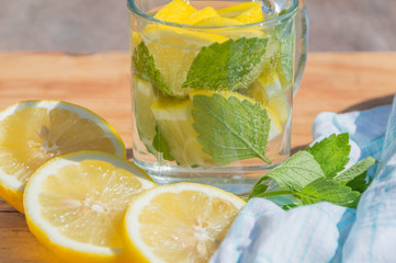 on a wooden table cool drink water with mint and lemon.