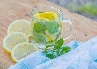 on the table summer drink is water with mint and lemon.