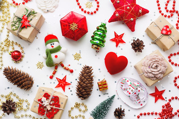 Christmas background with decorations. New Year symbol - decorative fir tree. Gifts in craft paper, pine cones, red hearts and confetti. Flay lay, top view.