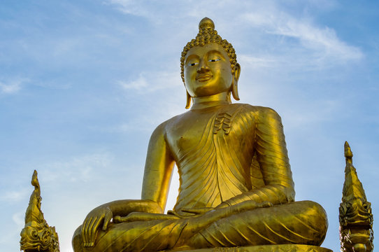 Golden statue of Buddha on blue sky background
